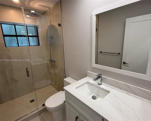 bathroom with toilet, a shower with door, and vanity