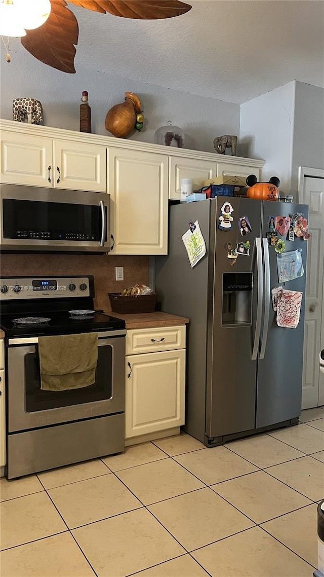 kitchen with white cabinetry, stainless steel appliances, and light tile patterned floors