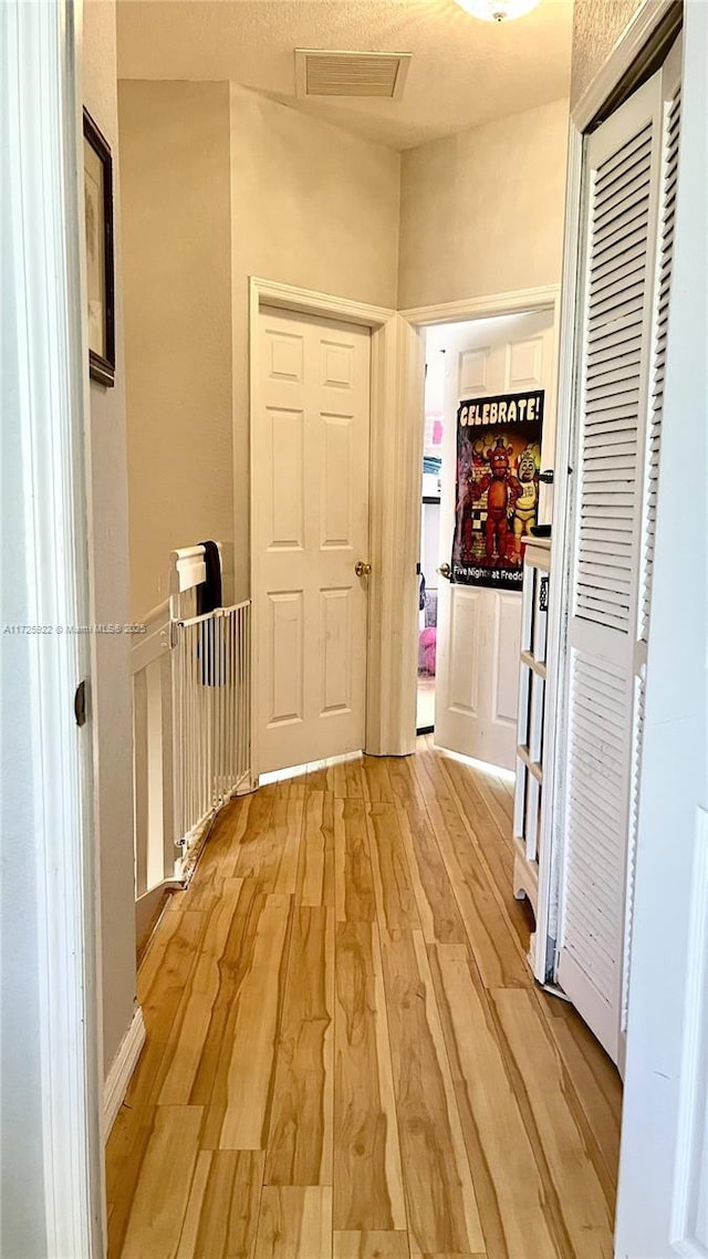 hallway with light hardwood / wood-style flooring