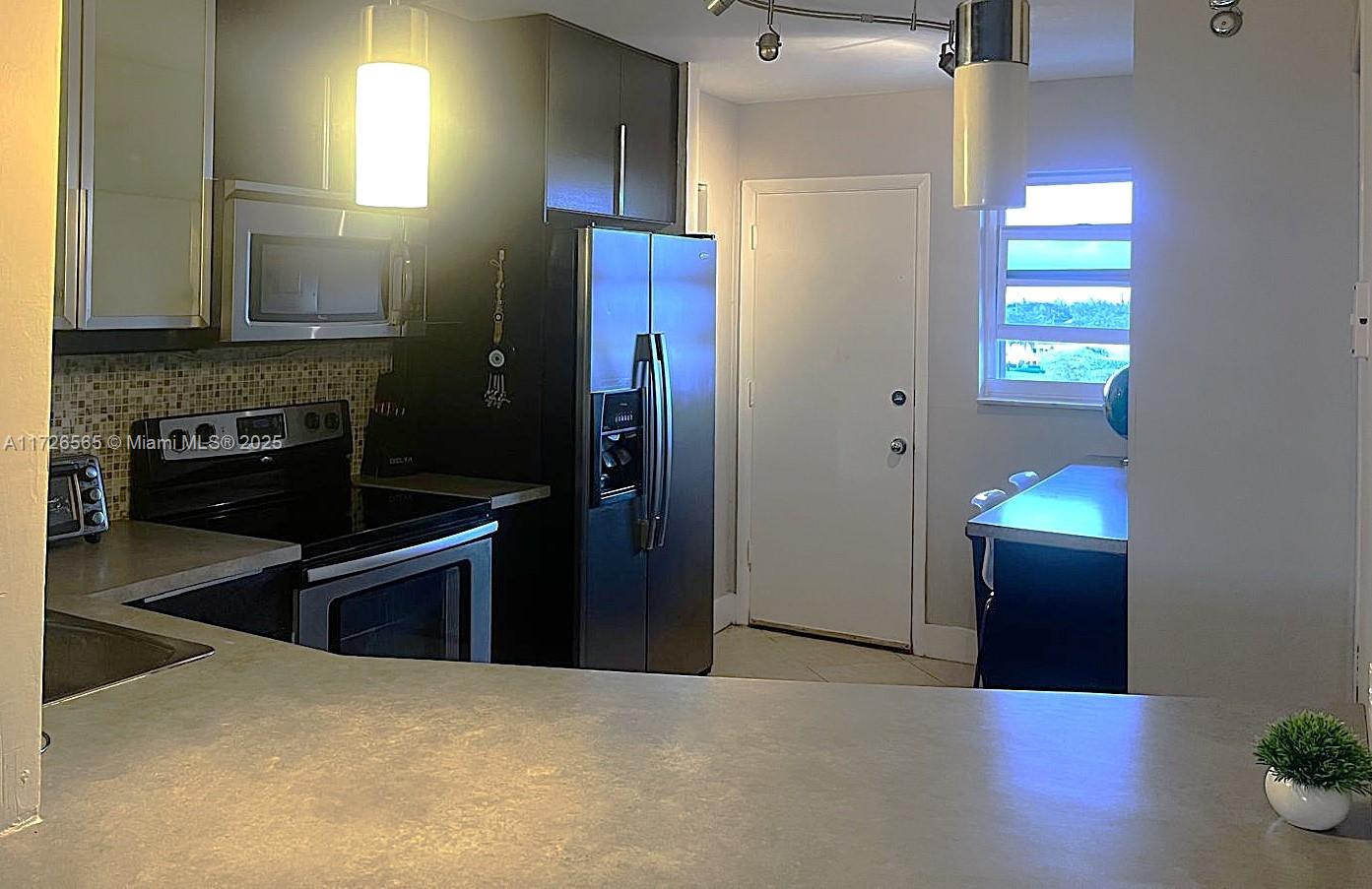 kitchen featuring appliances with stainless steel finishes, gray cabinetry, and tasteful backsplash