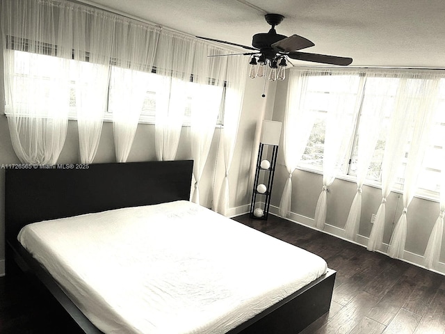 bedroom with multiple windows, ceiling fan, a textured ceiling, and dark hardwood / wood-style floors