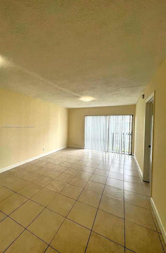 unfurnished room featuring light tile patterned flooring and a textured ceiling