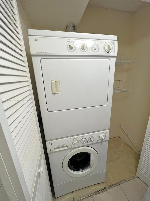 washroom with stacked washer / dryer and light tile patterned floors