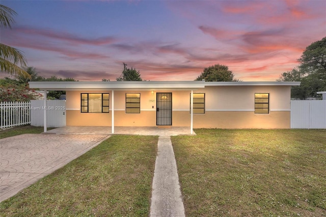 view of front of home featuring a lawn and a carport