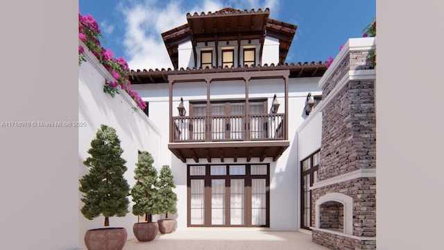 rear view of property featuring a balcony and stucco siding