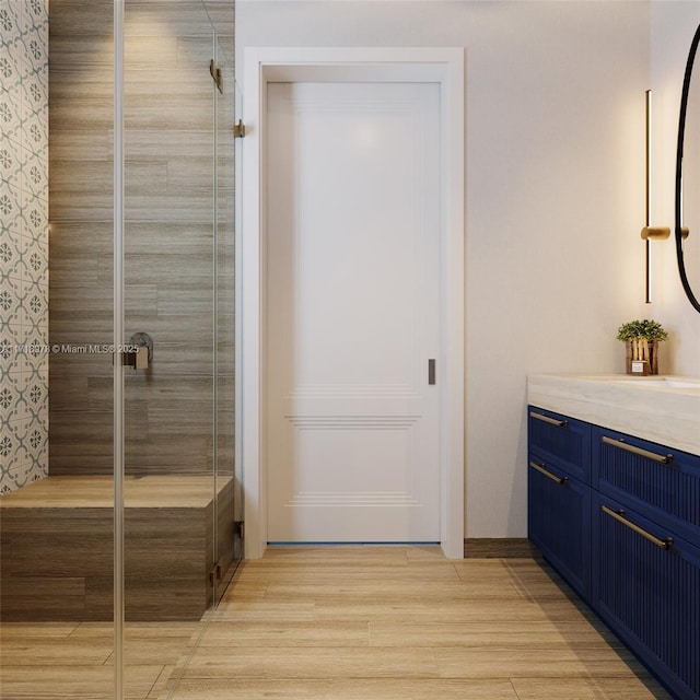 bathroom featuring a shower with door, vanity, and hardwood / wood-style floors