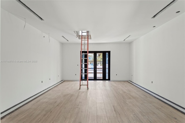 unfurnished room with wood finished floors and french doors