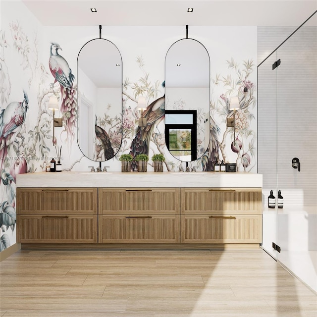 full bathroom featuring a shower stall, double vanity, and wood finished floors