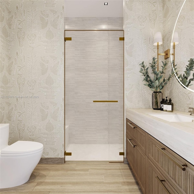 bathroom featuring toilet, an enclosed shower, hardwood / wood-style floors, and vanity