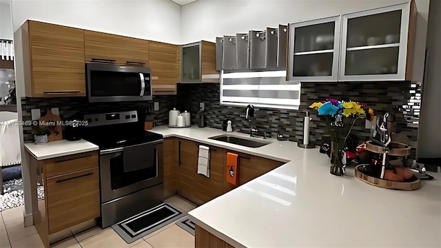 kitchen with sink, stainless steel appliances, backsplash, and light tile patterned floors