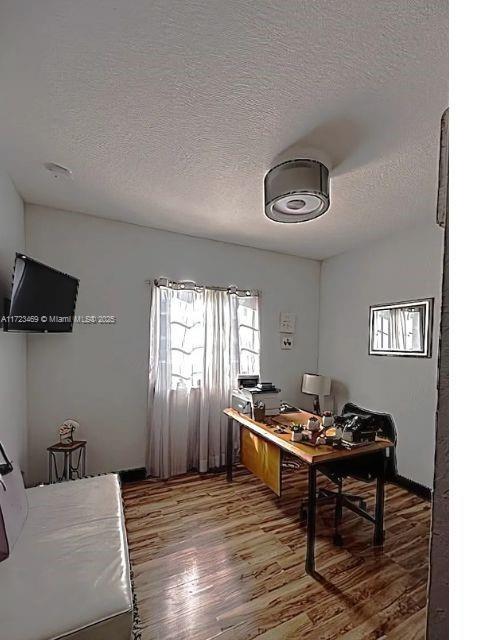 office space featuring wood-type flooring and a textured ceiling