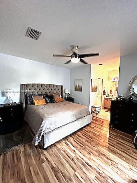 bedroom featuring a textured ceiling, ceiling fan, and light hardwood / wood-style floors