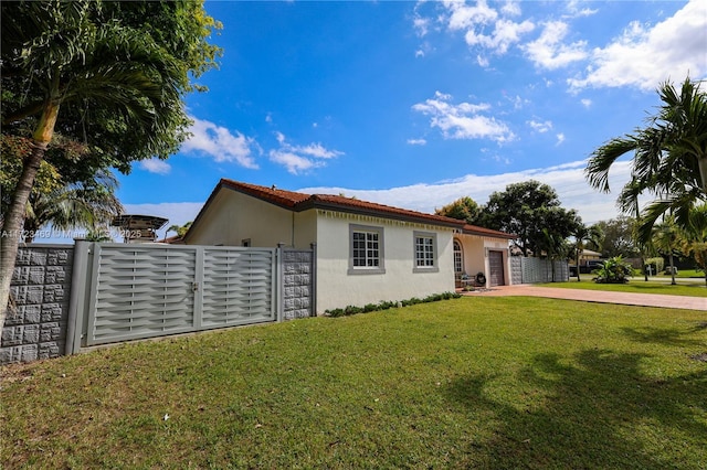 view of side of home featuring a lawn and a garage