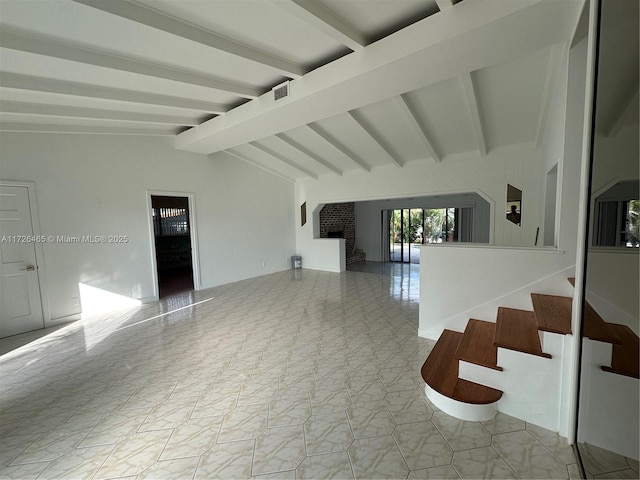 empty room with light tile patterned floors, a fireplace, and vaulted ceiling with beams