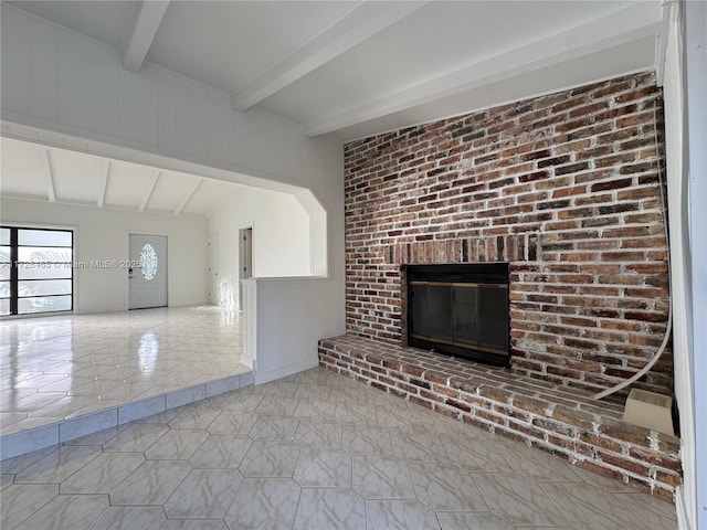 unfurnished living room with a brick fireplace and beamed ceiling