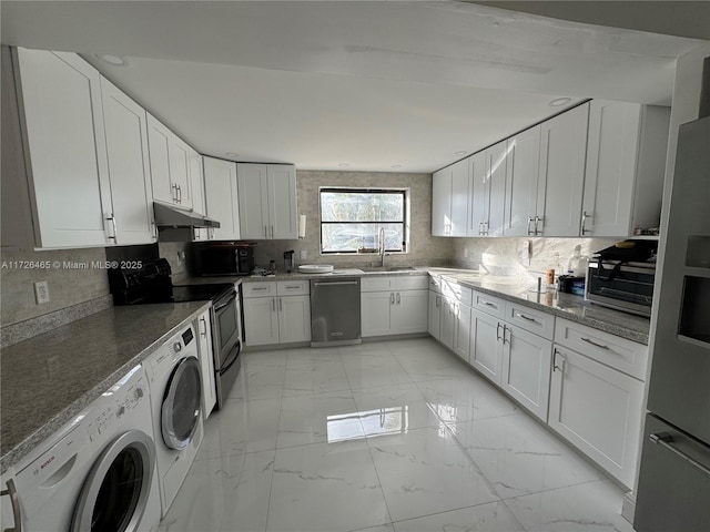 kitchen featuring washing machine and dryer, backsplash, white cabinets, appliances with stainless steel finishes, and sink