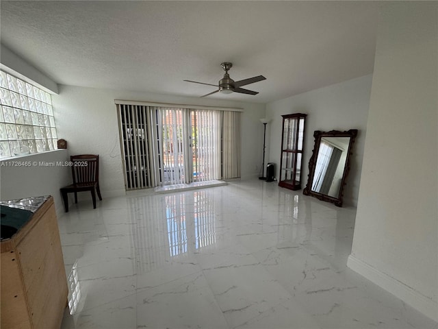 empty room featuring a textured ceiling and ceiling fan