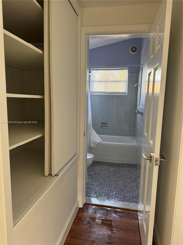 bathroom featuring toilet, hardwood / wood-style flooring, and shower / bath combo