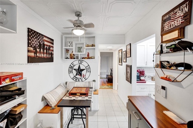 interior space with ceiling fan and ornamental molding