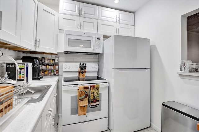 kitchen featuring light tile patterned floors, backsplash, white cabinets, and white appliances