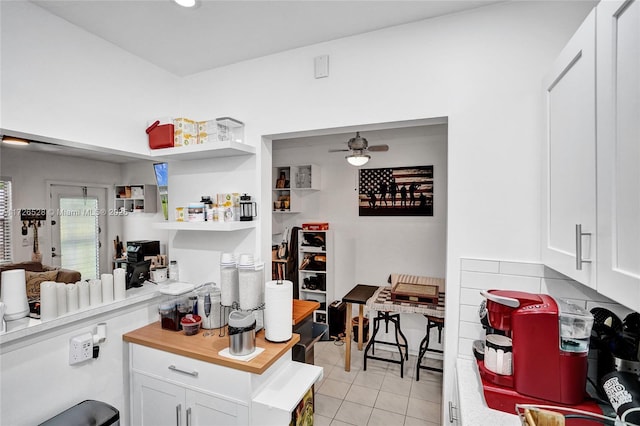 kitchen featuring light tile patterned flooring, ceiling fan, and white cabinetry