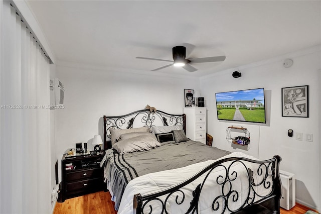 bedroom featuring ceiling fan, crown molding, and light hardwood / wood-style flooring