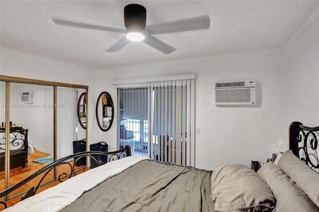 bedroom with ceiling fan, a wall mounted AC, a closet, and wood-type flooring