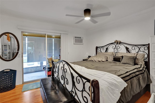 bedroom with ceiling fan, hardwood / wood-style floors, access to outside, and a wall mounted air conditioner