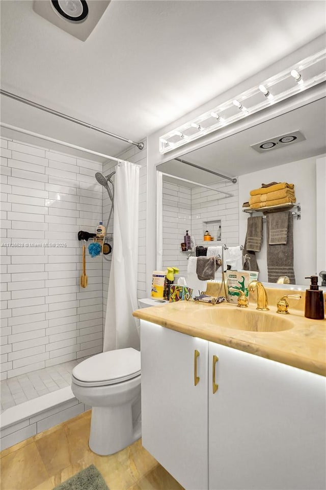 bathroom with toilet, tile patterned floors, vanity, and curtained shower