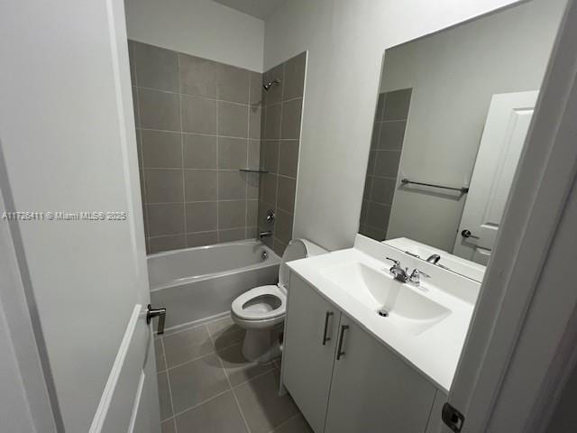 full bathroom featuring vanity, tile patterned flooring, toilet, and tiled shower / bath