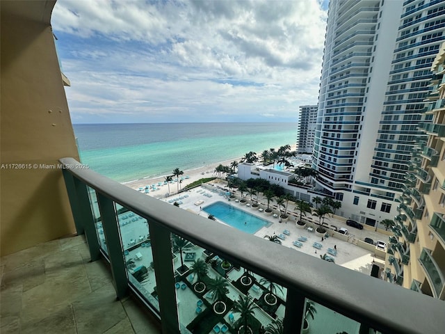 balcony featuring a beach view and a water view