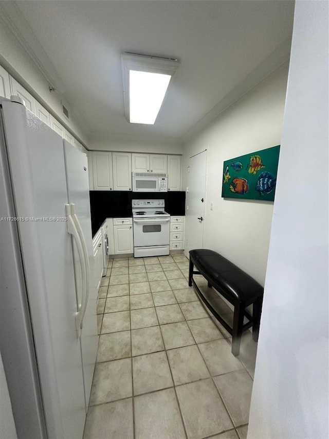 kitchen with white appliances, white cabinets, light tile patterned flooring, and ornamental molding