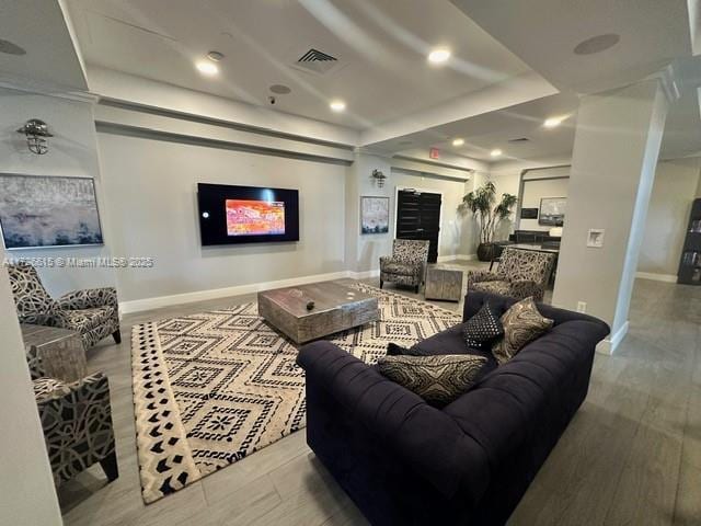 living room with hardwood / wood-style floors and a tray ceiling