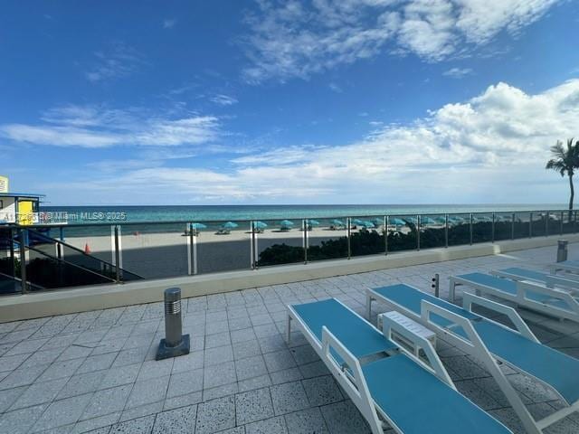 view of patio / terrace with a water view and a view of the beach