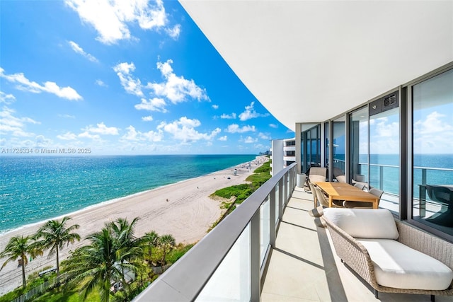 balcony with a water view and a view of the beach