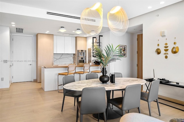 dining area featuring light hardwood / wood-style flooring and sink