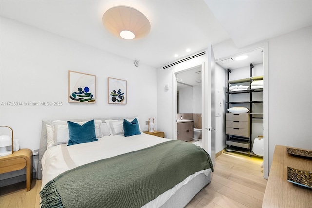 bedroom featuring hardwood / wood-style floors and connected bathroom