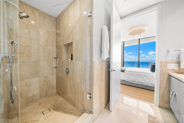 bathroom with floor to ceiling windows, a shower with shower door, and a water view