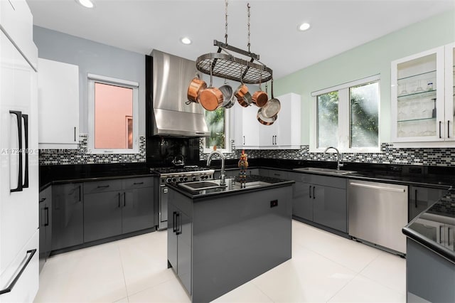 kitchen featuring a center island, range hood, high quality appliances, white cabinets, and sink