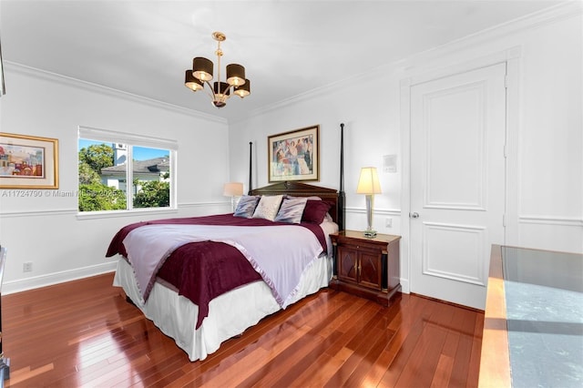 bedroom with dark hardwood / wood-style floors, a closet, ornamental molding, and an inviting chandelier