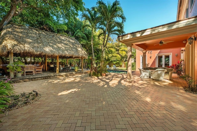 view of patio / terrace featuring ceiling fan, a gazebo, french doors, and an outdoor living space