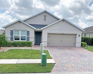 ranch-style house featuring a garage and a front lawn