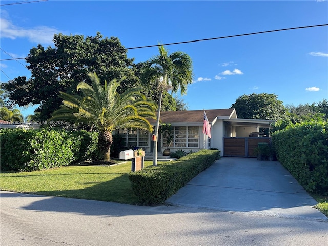 view of front of property with stucco siding, driveway, a front yard, and a gate