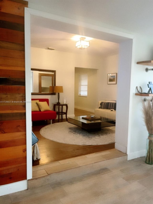 living area with visible vents, baseboards, and wood finished floors