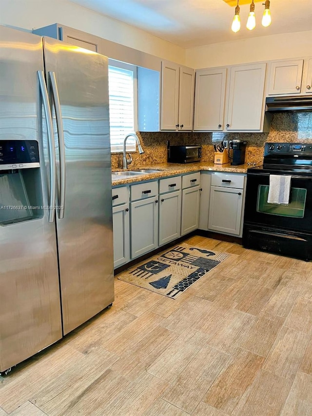 kitchen featuring black range with electric stovetop, stainless steel refrigerator with ice dispenser, a sink, under cabinet range hood, and backsplash