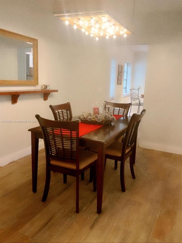 dining room featuring baseboards and light wood finished floors