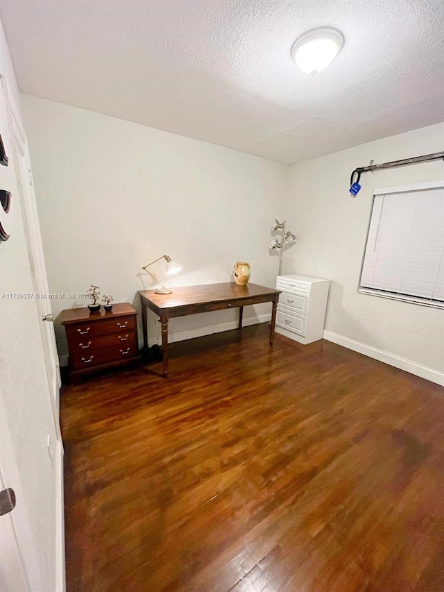 bedroom featuring a textured ceiling, baseboards, and wood finished floors