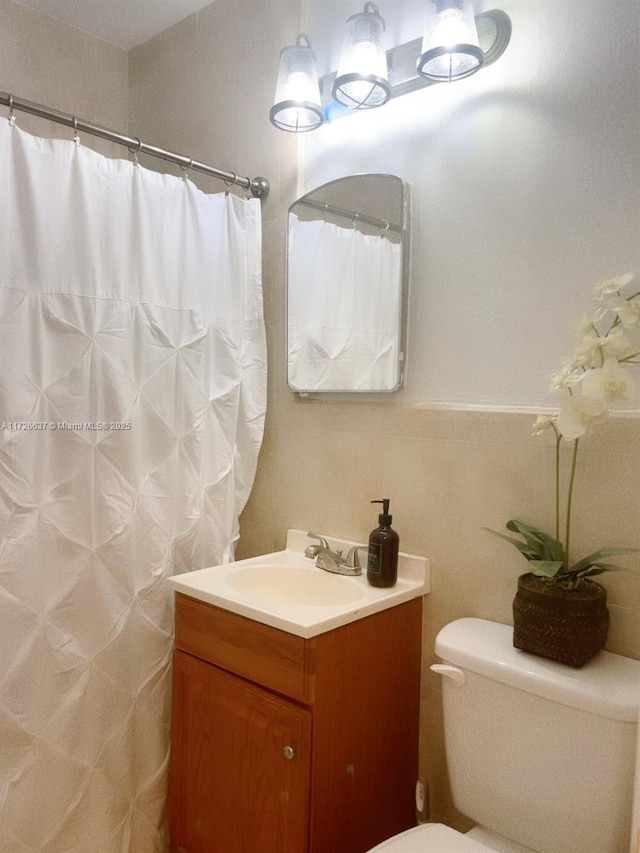 bathroom featuring vanity, a shower with shower curtain, and toilet