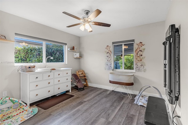 bedroom with sink, ceiling fan, and wood-type flooring