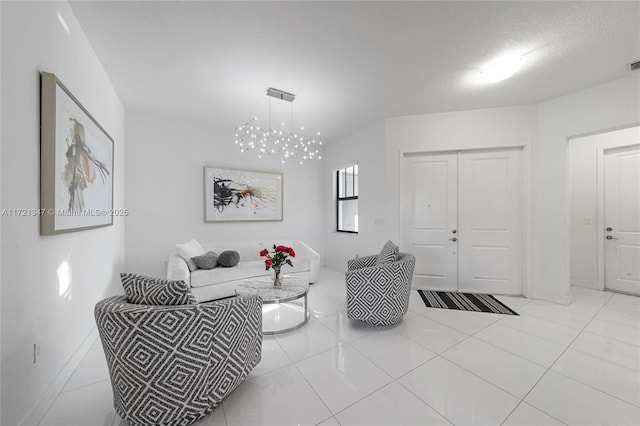 tiled living room featuring a textured ceiling and a notable chandelier